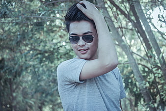 Young man in sunglasses posing outdoors in nature