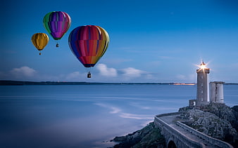 Colorful Hot Air Balloons Flying Over Coastal Lighthouse at Twilight