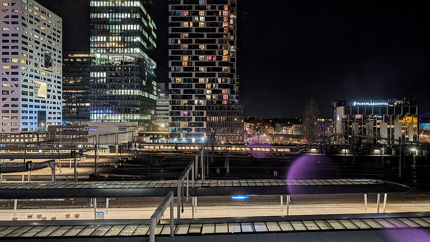 Nighttime Cityscape with Train Station and Modern High-Rise Buildings