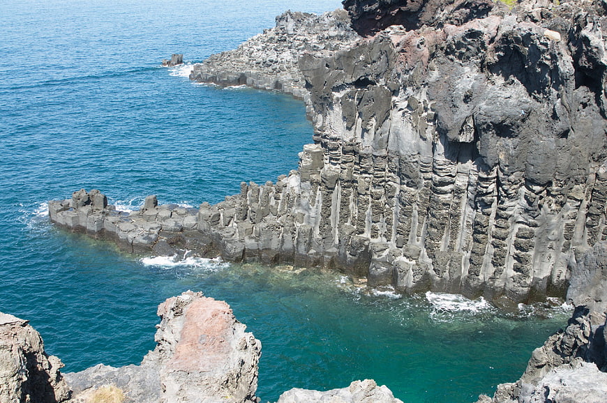 Dramatic volcanic rock formations along a rugged ocean coastline