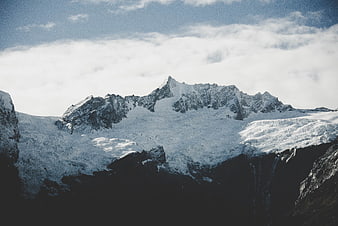 Majestic Snow-Capped Mountain Peak Above Clouds