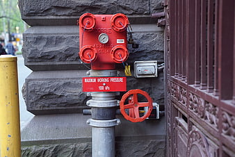 Red Fire Hydrant Valve on Stone Wall