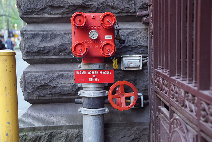 Red Fire Hydrant Valve on Stone Wall