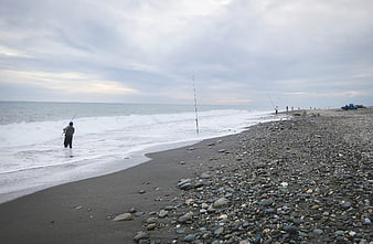 Fishermen on Rocky Beach with Ocean Waves