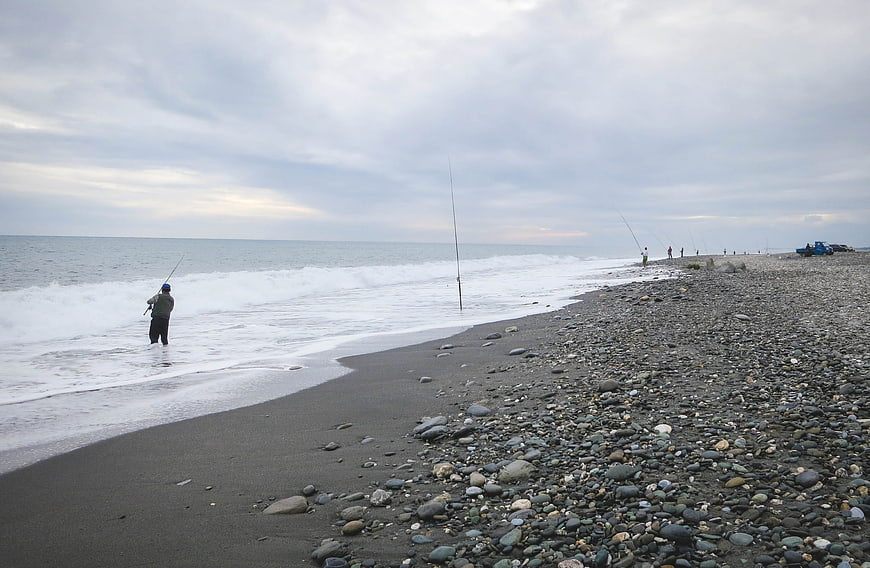 Fishermen on Rocky Beach with Ocean Waves