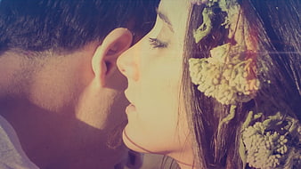 Close-up of romantic couple whispering with flowers in hair