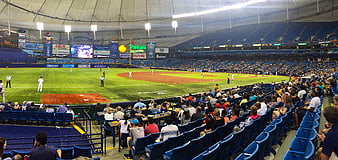 Wide view of baseball game in indoor stadium with crowd