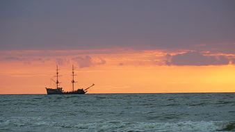 Silhouette of Tall Ship on Ocean at Sunset