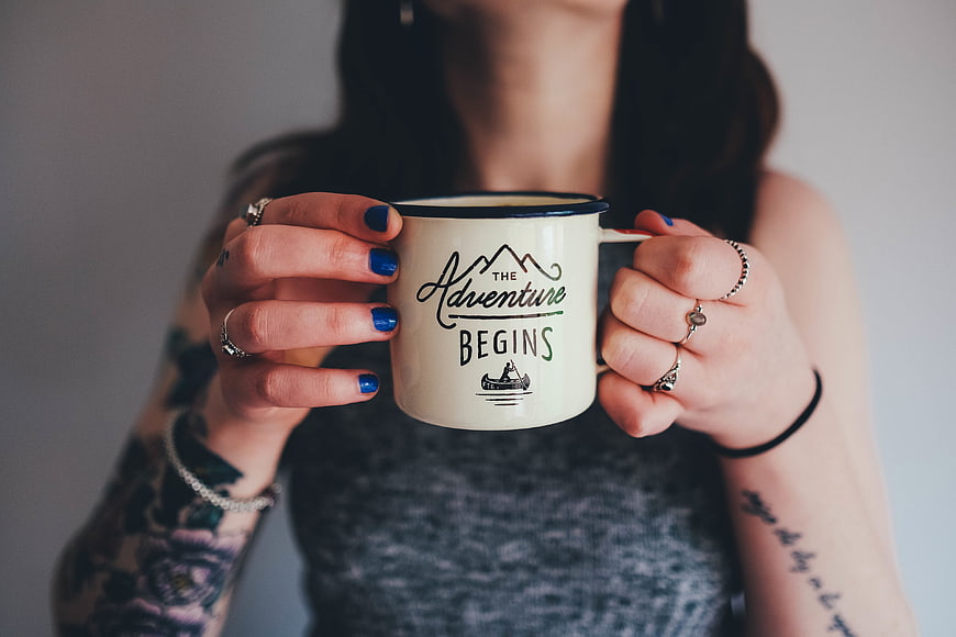 Woman Holding Adventure Begins Coffee Mug