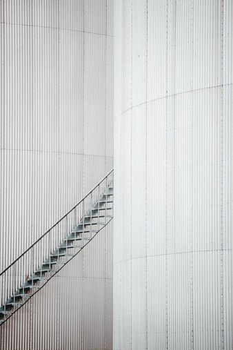 Abstract industrial metal stairs on white corrugated tank wall