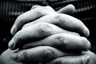 Close-up of clasped hands in black and white
