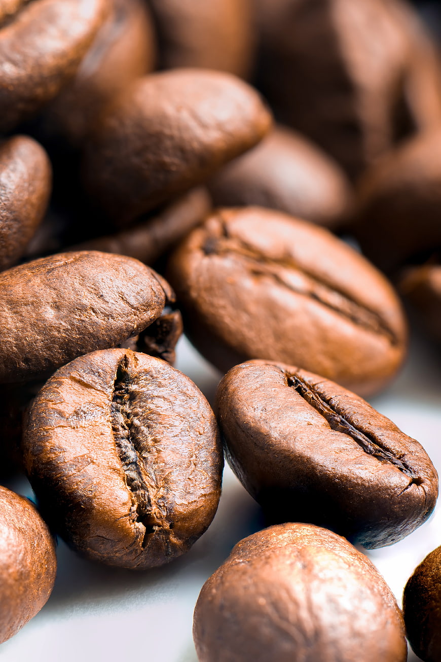 Close-up of roasted coffee beans on white background