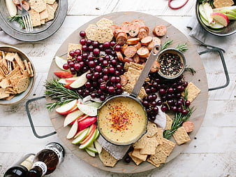 Overhead view of charcuterie board with cheese dip, grapes, and crackers