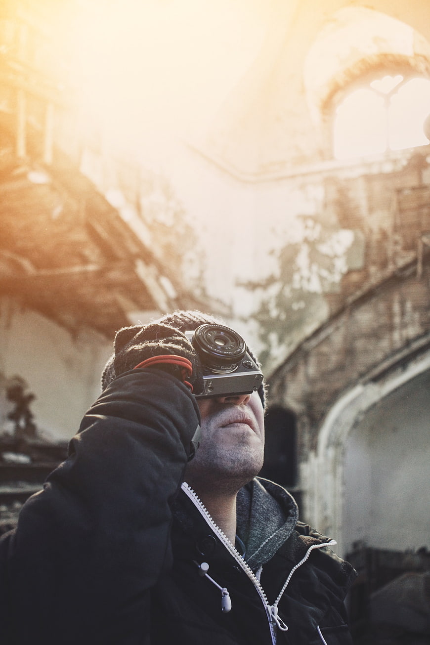Man with Vintage Camera in Sunlit Ruins