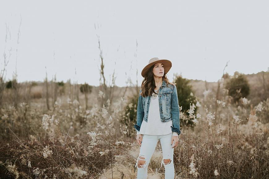 Woman in Denim Jacket and Hat Standing in Dry Field