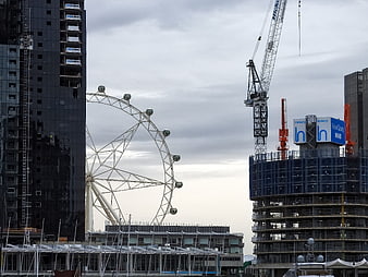 London Eye Ferris Wheel with Construction Cranes and Buildings