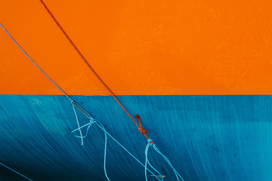 Abstract orange and blue painted wall with ropes