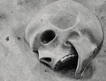 Close-up of weathered stone skull sculpture in church