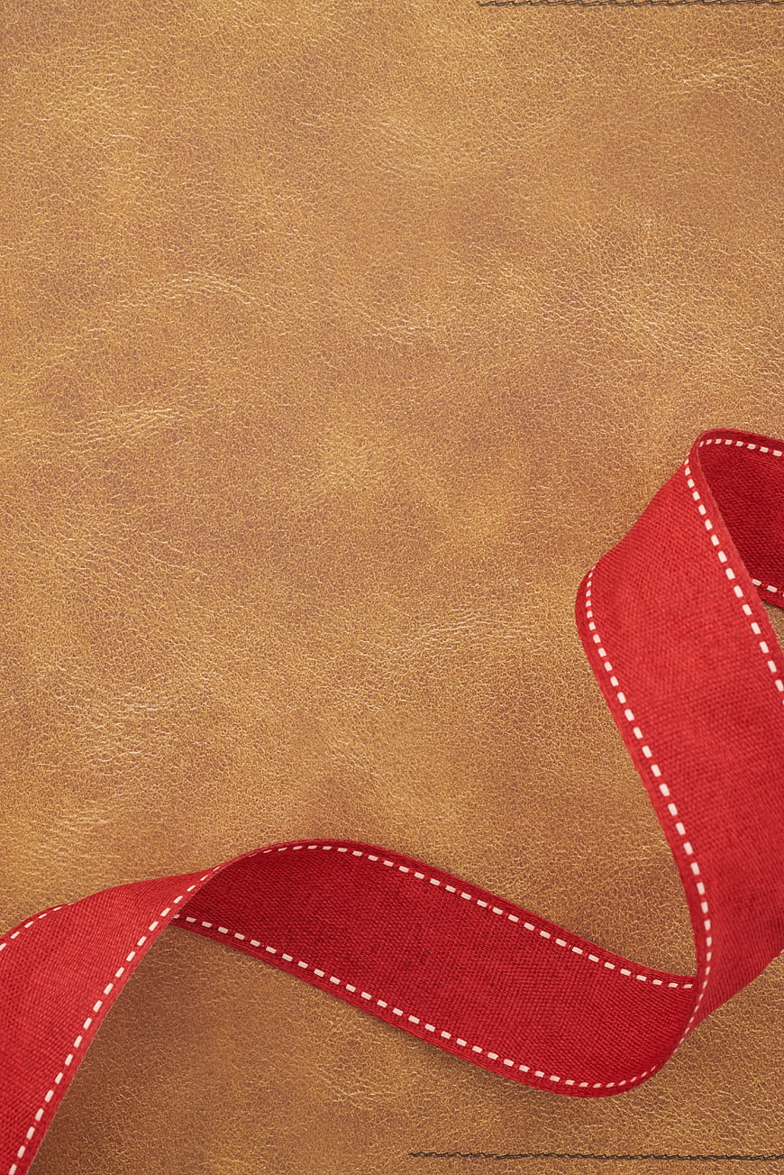 Red Ribbon on Brown Leather Background with Copyspace