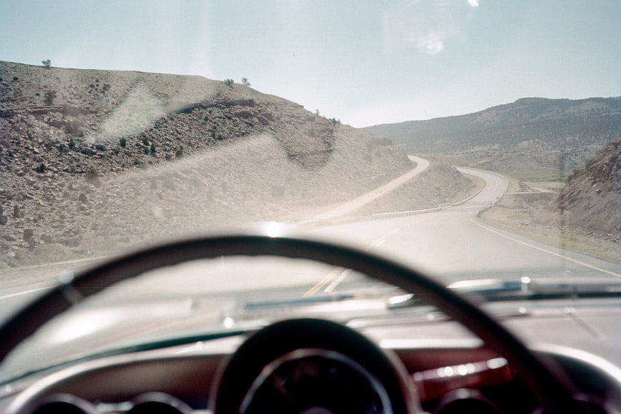 Vintage car dashboard view on winding desert highway