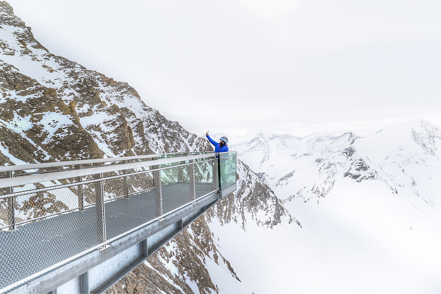 Hiker taking selfie on snowy mountain skywalk