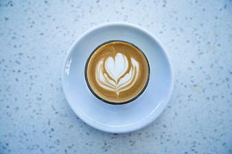 Top view of latte art coffee on white saucer