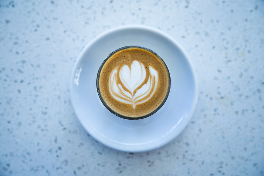 Top view of latte art coffee on white saucer
