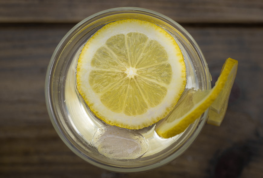 Top View of Fresh Lemon Water with Ice on Wood
