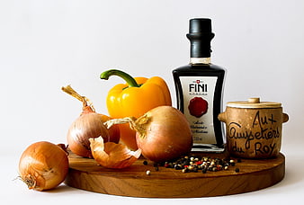 Balsamic vinegar, onions, and yellow pepper on wooden board