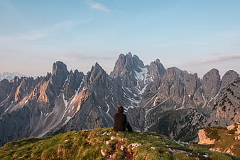 Lone Hiker Sitting on Mountain Ridge at Sunset