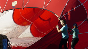 Couple Inflating Large Red Hot Air Balloon