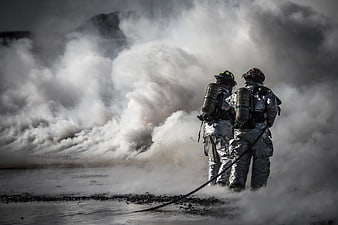 Two Firefighters in Proximity Suits Battling Smoke