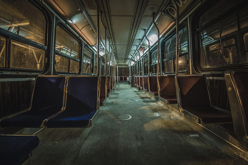 Empty subway car interior with blue seats and gritty atmosphere