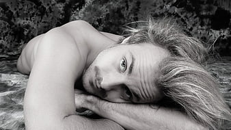 Black and white portrait of shirtless man lying down