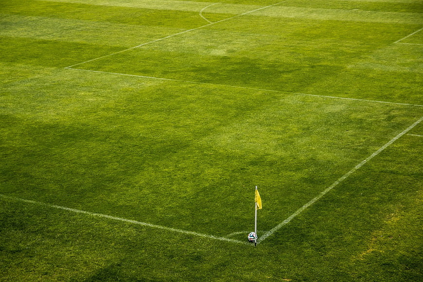 High Angle View of Soccer Ball and Corner Flag on Green Pitch