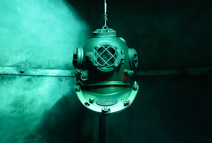 Vintage Brass Diving Helmet Hanging on Dark Wall