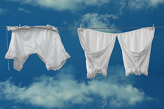 White Lace Underwear Hanging on Clothesline Against Blue Sky