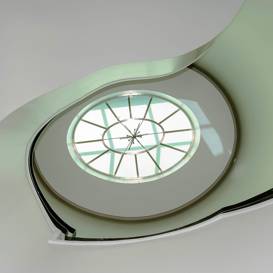 Modern spiral staircase looking up to circular skylight