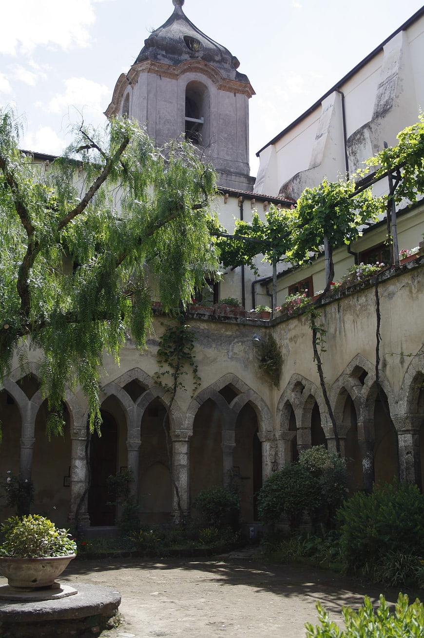 Historic Italian monastery courtyard with stone arches and bell tower