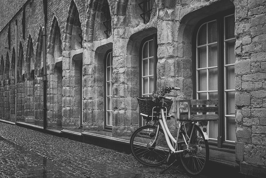 Vintage Bicycle Parked on Cobblestone Street in Black and White