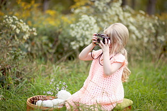 Cute Blonde Girl Taking Photos with Vintage Camera in Nature