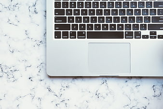 Silver MacBook Keyboard And Trackpad On White Marble Surface