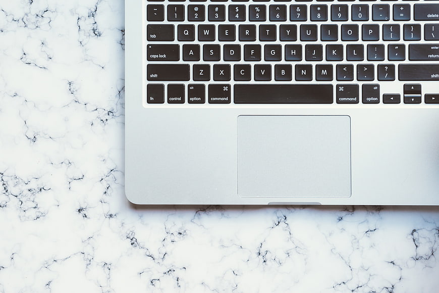Silver MacBook Keyboard And Trackpad On White Marble Surface