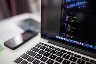 Close-up of laptop screen displaying CSS code and keyboard