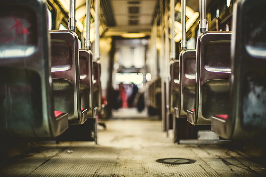 Empty subway car interior with metal seats and blurred passengers