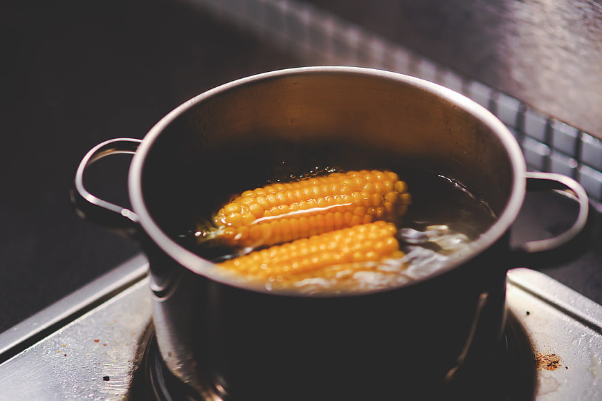 Boiling corn on the cob in a metal pot