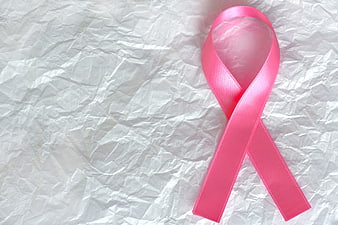 Pink Ribbon on Crumpled White Paper Background