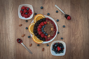 Healthy breakfast bowl with quinoa, berries, and orange slices on wood