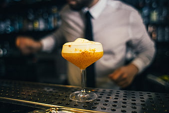 Craft cocktail with foam and spice garnish on bar counter
