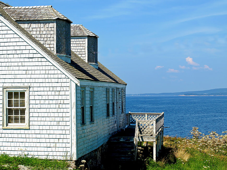 Weathered White Coastal Cottage Overlooking Blue Ocean